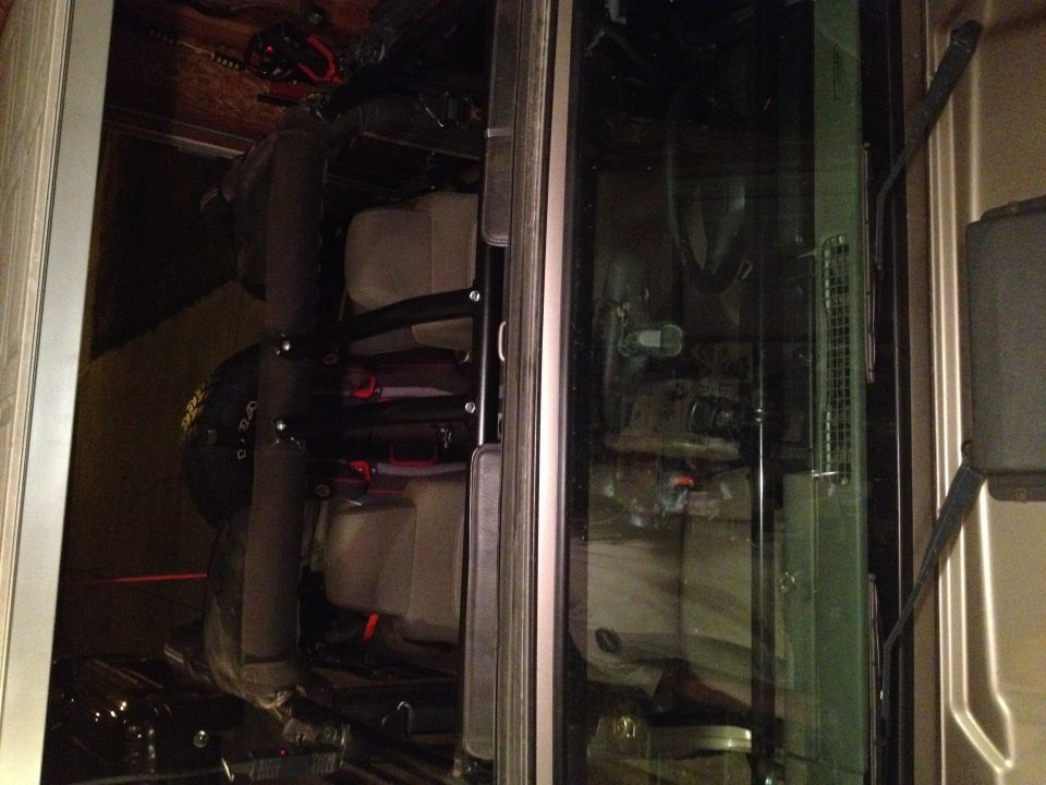 Interior of a vehicle showing seats and storage, with a black helmet.