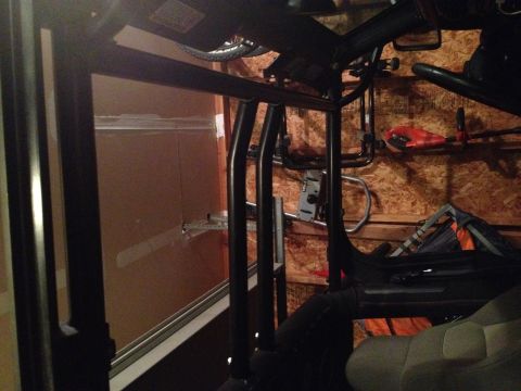 2005 Jeep Wrangler - The image shows a partial view of a black treadmill frame and a seat, possibly from a vehicle, in a garage setting with wood-paneled walls.…