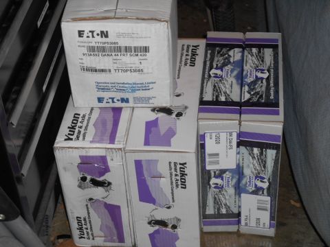 1994 Ford Bronco - A stack of automotive differential component boxes, including Eaton and Yukon Gear & Axle brands, are arranged on a shelf.