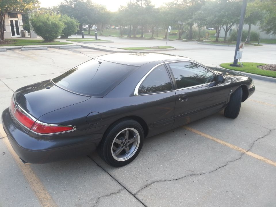 Dark gray 1998 Lincoln Mark VIII coupe, rear passenger side view, aftermarket wheels