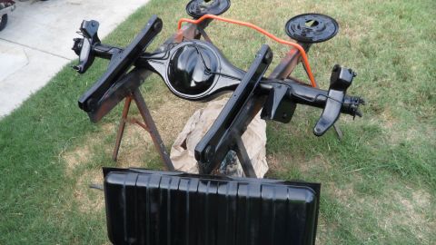 1972 Ford Ranchero - A freshly painted rear axle assembly and fuel tank are displayed on sawhorses, ready for installation.