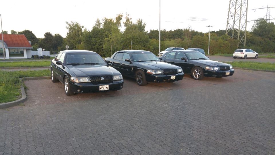 Three black 2003 Mercury Marauders parked in a lot. One is closer to the camera