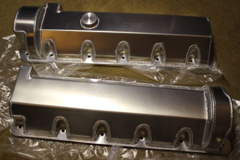 2003 Ford Crown Victoria - Two fabricated aluminum valve covers with rope-style welds and a filler cap, one stamped Moroso, laid on carpet in plastic wrap.