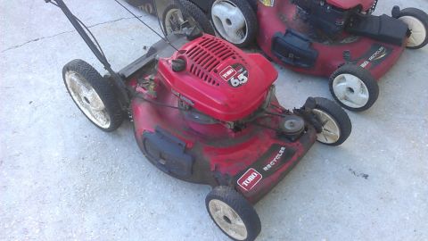 2006 Honda RANCHER - Two red Toro Recycler lawn mowers are parked on a concrete surface. The front mower has a 6.5 HP engine.