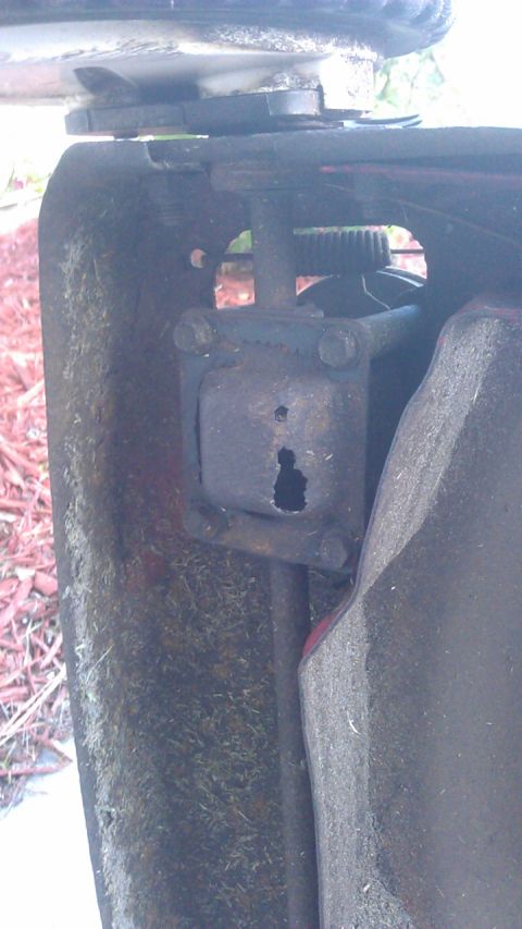 2006 Honda RANCHER - Detail of a worn and rusted lawnmower deck component, showing signs of significant use and age.