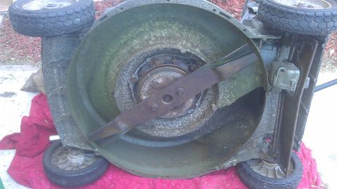 2006 Honda RANCHER - Underside view of a lawn mower deck with a rusty blade visible.