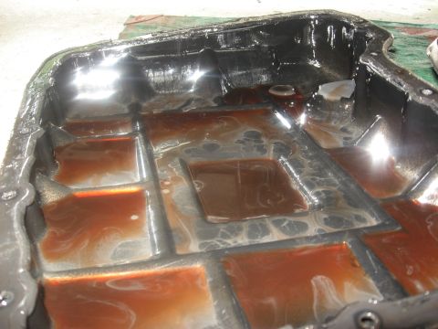 1994 Ford Bronco - Transmission pan filled with fluid, showing signs of use and potential wear.