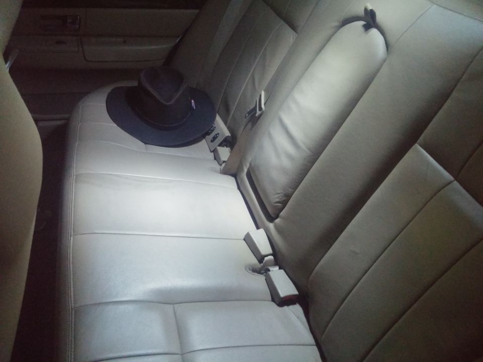 Back seat interior of a car with a dark hat on the seat