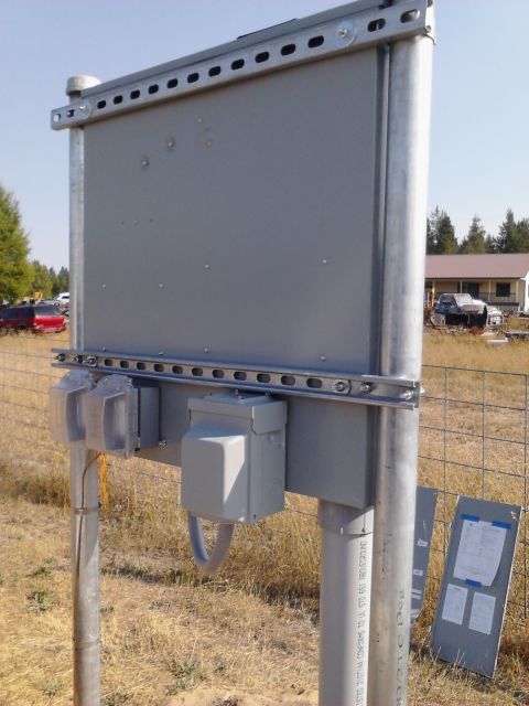 1989 Ford Bronco - An outdoor electrical enclosure is shown with a fence and vehicles in the distance.