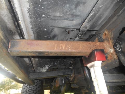1994 Ford Bronco - Close-up of vehicle undercarriage, focusing on a metal bar and jack support.