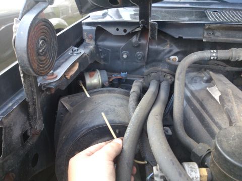 1995 Ford Bronco - A view of the engine bay, focusing on hoses and a small cylindrical component.