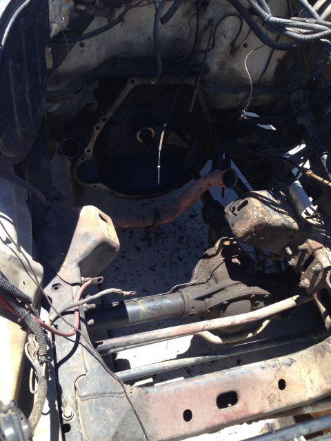 1978 Ford Bronco - The engine bay of a vehicle is shown, focusing on the transmission and exhaust system components.