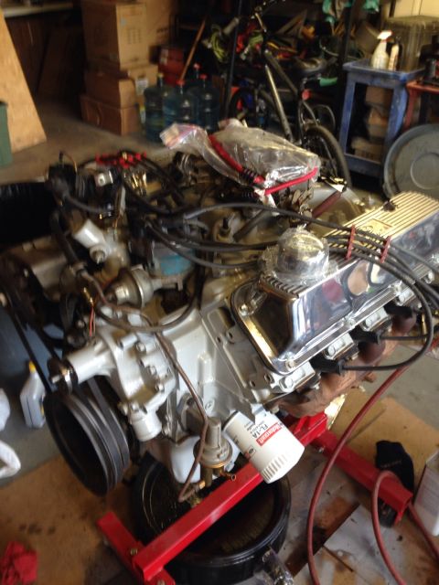 1978 Ford Bronco - A V8 engine is mounted on a stand, ready for installation or repair, with various garage items in the background.