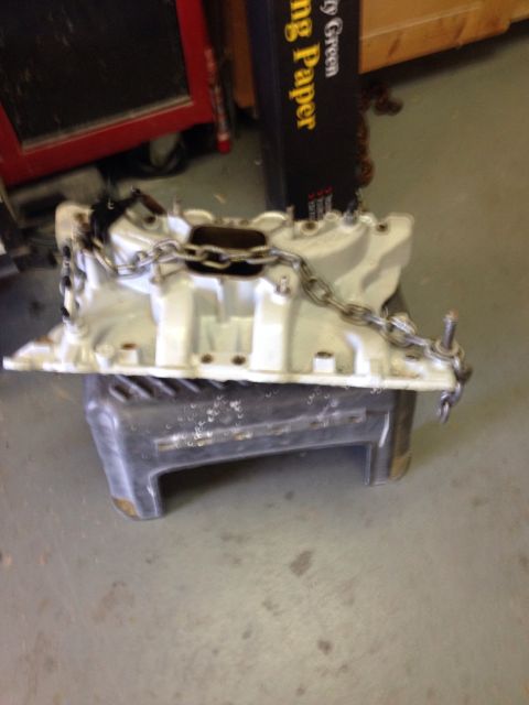 1978 Ford Bronco - Engine intake manifold with chain, possibly for an engine swap project.