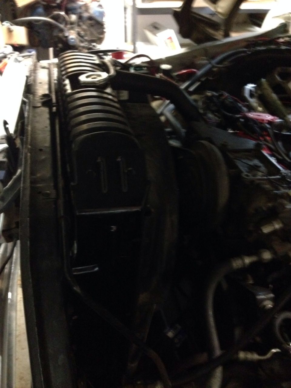 Radiator and engine bay of a vehicle, with visible wiring and hoses