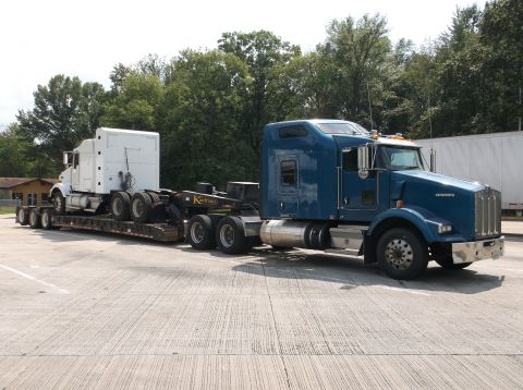 2011 Harley-Davidson Elec Gld Police - A blue Kenworth semi-truck transports a white semi-truck on its trailer.