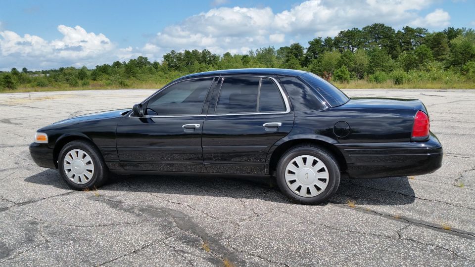2001 Ford Crown Victoria, side view, black paint, tinted windows, parked outdoors