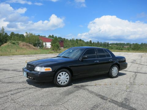 2001 Ford Crown Victoria - A black 2001 Ford Crown Victoria is seen from a three-quarter front angle on a sunny day.