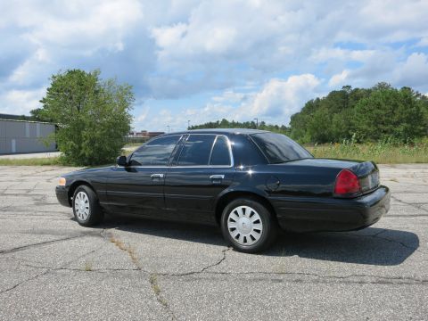 2001 Ford Crown Victoria - A black 2001 Ford Crown Victoria is shown from the rear quarter angle on a cloudy day.