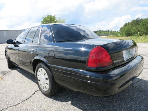 2001 Ford Crown Victoria - Rear view of a black 2001 Ford Crown Victoria sedan with tinted windows.