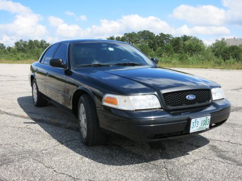 2001 Ford Crown Victoria - This black Ford Crown Victoria is parked outdoors on a sunny day.