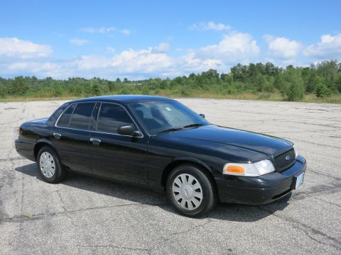 2001 Ford Crown Victoria - A black 2001 Ford Crown Victoria is shown from a three-quarter front view in an outdoor setting.