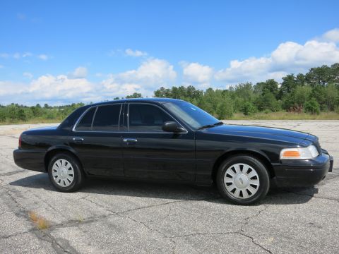 2001 Ford Crown Victoria - Side view of a black 2001 Ford Crown Victoria parked outdoors on a sunny day.