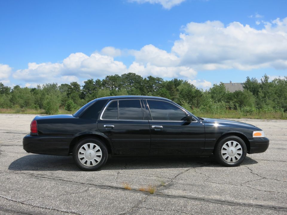 2001 Ford Crown Victoria parked on cracked asphalt, side view