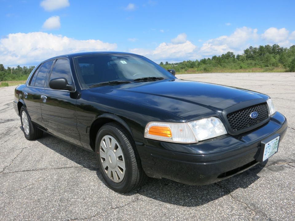 Black sedan parked on asphalt, front quarter view. Visible license plate reads '373-108'