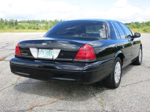2001 Ford Crown Victoria - The rear of a black 2001 Ford Crown Victoria sedan is shown from a 3/4 angle.