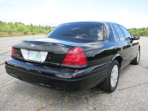 2001 Ford Crown Victoria - Rear view of a black 2001 Ford Crown Victoria sedan parked on asphalt.