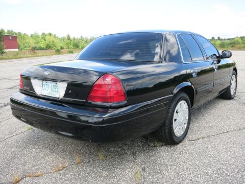 2001 Ford Crown Victoria - Rear quarter view of a black 2001 Ford Crown Victoria sedan parked on asphalt.