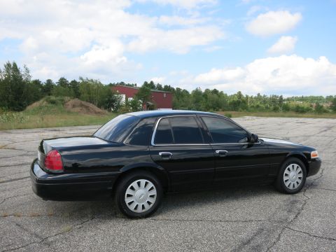 2001 Ford Crown Victoria - Side view of a black 2001 Ford Crown Victoria parked outdoors on a paved surface.