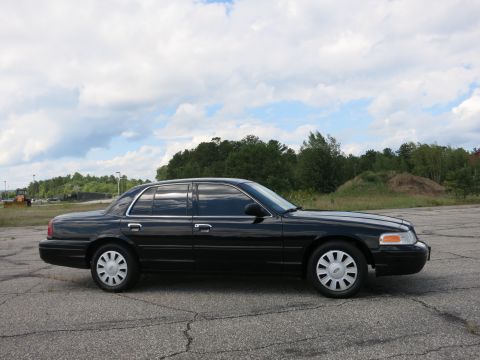 2001 Ford Crown Victoria - Side view of a black 2001 Ford Crown Victoria sedan parked outdoors.