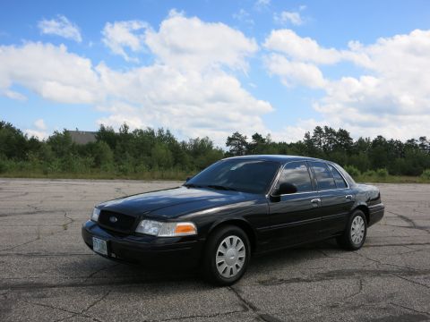 2001 Ford Crown Victoria - Black 2001 Ford Crown Victoria sedan parked outdoors under a cloudy sky.