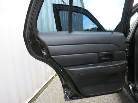 2001 Ford Crown Victoria - The interior of a car's rear door is shown, with the door open to reveal the panel and window.