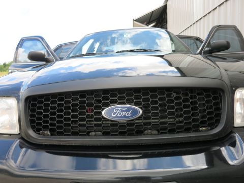2001 Ford Crown Victoria - Front view of a black 2001 Ford Crown Victoria, its distinctive honeycomb grille and Ford emblem.