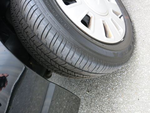2001 Ford Crown Victoria - Close-up view of a car's tire and wheel assembly, showing the tread pattern.