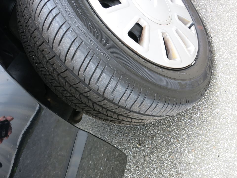 Close-up of a car tire with tread detail and a silver alloy wheel