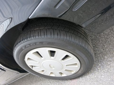 2001 Ford Crown Victoria - A close-up view of a vehicle's tire and wheel assembly, showing the tread pattern and hubcap design.