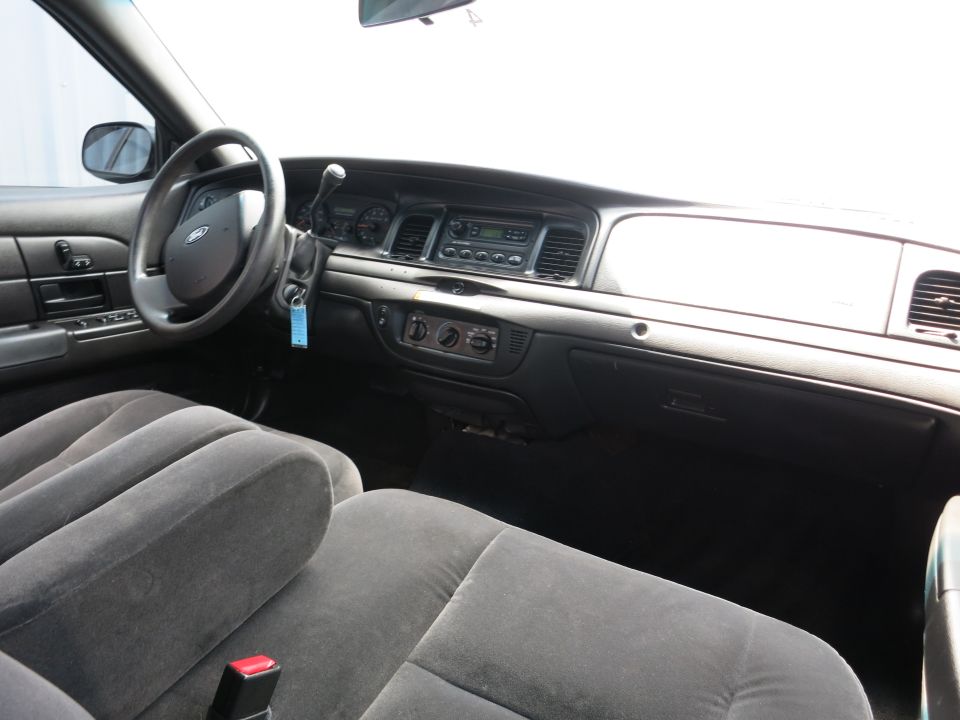 Car interior with gray cloth seats, dashboard, steering wheel, and radio