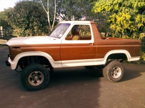 1982 Ford Bronco - This lifted Ford Bronco is shown from the side, a two-tone brown and white paint scheme.
