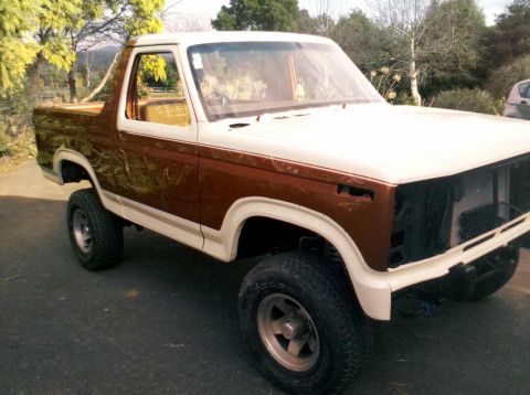 1982 Ford Bronco - This 1982 Ford Bronco features a two-tone brown and white paint scheme with custom graphics on the rear quarter panel.