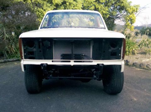 1982 Ford Bronco - Front view of a white truck, likely from the early 1980s, with its grille and headlights removed.