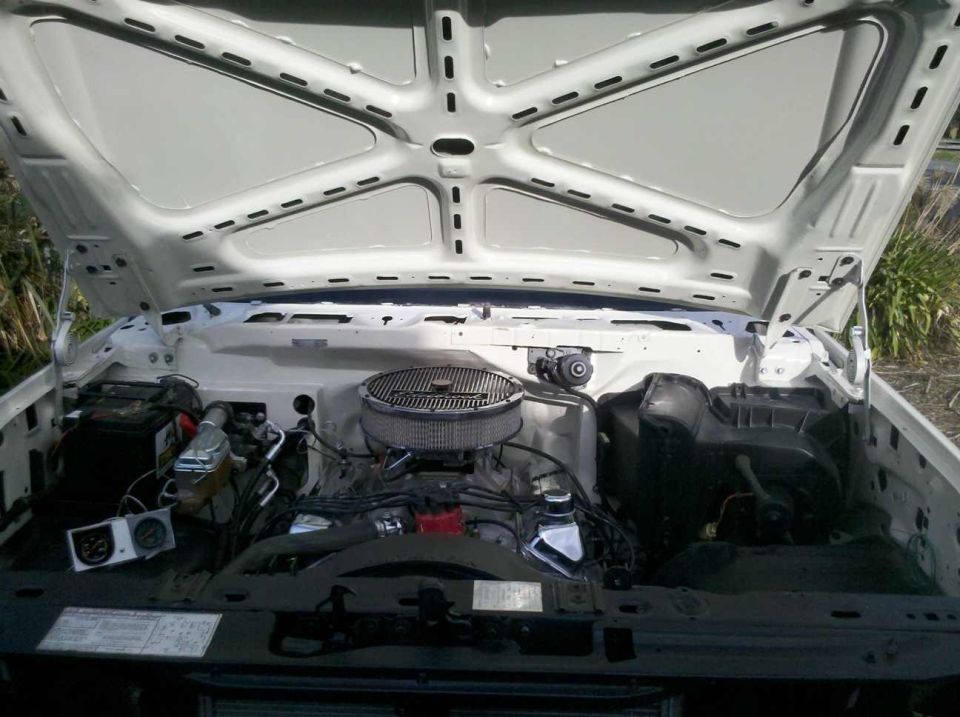 1982 Ford Bronco engine bay with V8 engine, air cleaner, and battery visible