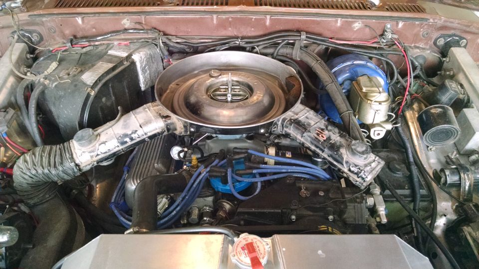 Engine bay with air cleaner, hoses, and wiring visible. Supermotors.net logo in lower right