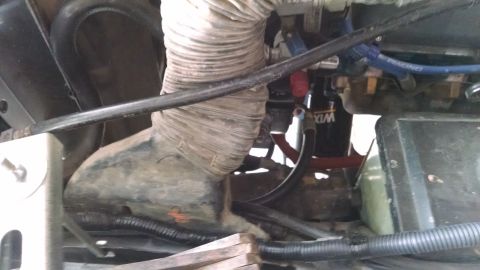 1979 Ford F-150 - Close-up view of engine bay components including a large hose and oil filter.