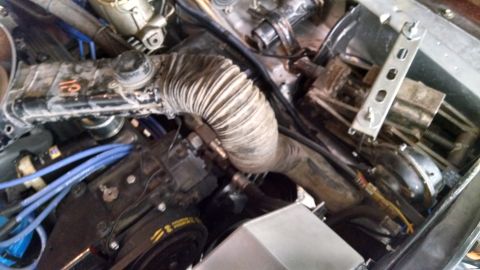 1979 Ford F-150 - Close-up view of an engine bay, highlighting a dual snorkel air cleaner assembly and blue spark plug wires.