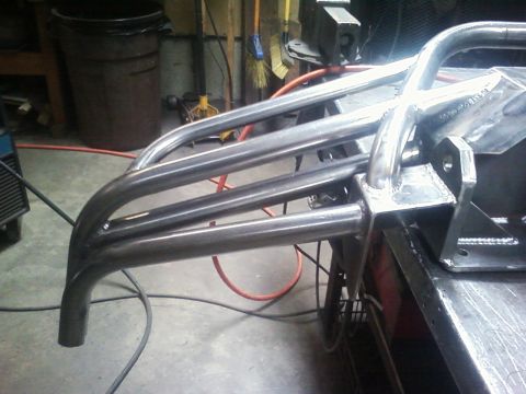 1989 Ford Bronco - Custom tube bumper with multiple horizontal bars and a vertical support, welded metal construction.