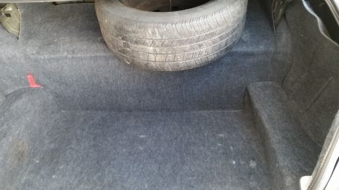 2001 Ford Crown Victoria - Interior view of a car's trunk, a spare tire and carpet lining.